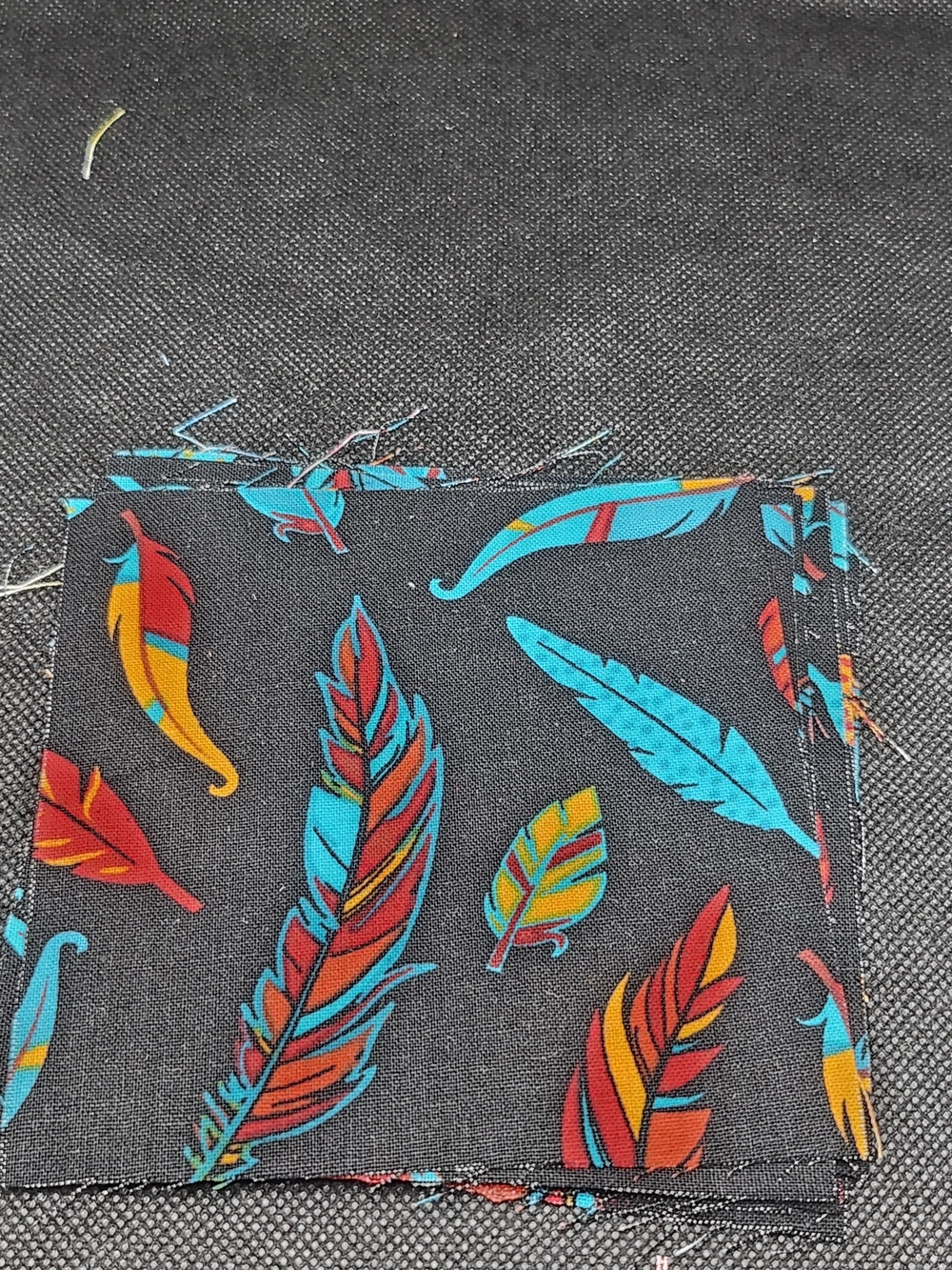 Black Feather-Print Fabric Swatch with Turquoise, Red & Yellow Accents